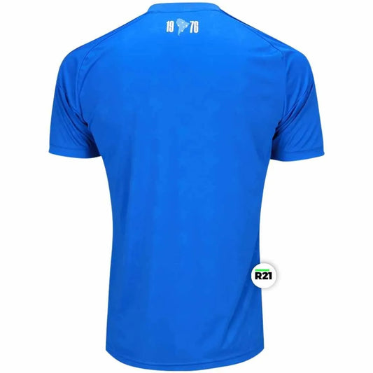 Vista das costas da camisa do Cruzeiro 2026 com detalhe do mapa da América do Sul e 1976 o ano do título da Libertadores na nuca